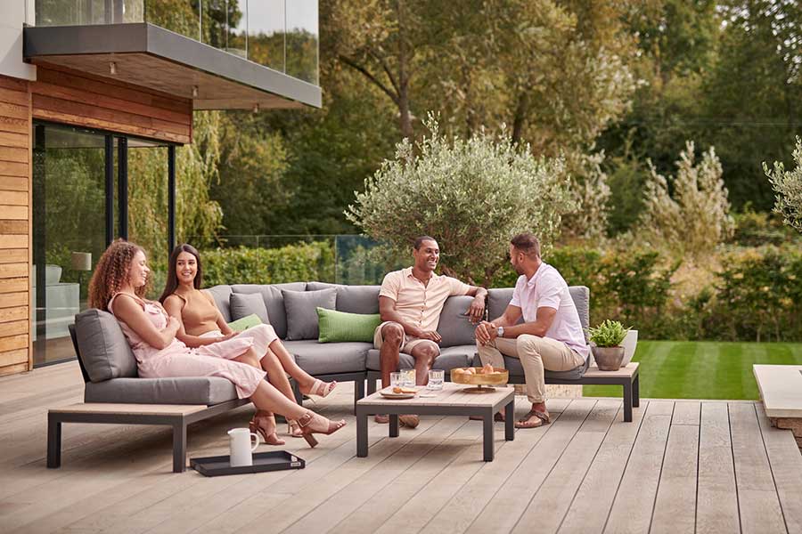 Friends enjoying drinks on Kettler luxury furniture in a stylish garden